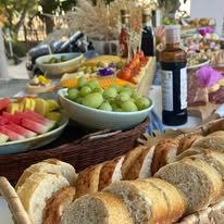 Mesa de catering con panes, frutas y botanas